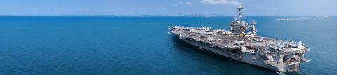 An aircraft carrier floats on the ocean