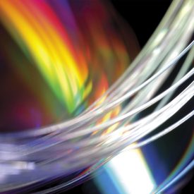 Extreme closeup of curves of clear glass fiber, multicolored background