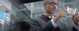 Photo à insérer : Jeune homme consultant son téléphone portable dans un décor de bureau en verre