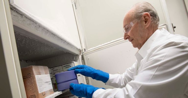 Scientist handling a CoolBox in a freezer 