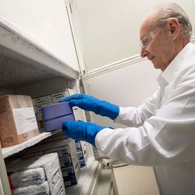 Scientist handling a CoolBox in a freezer