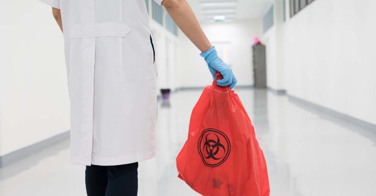 Scientist holding waste bag from lab