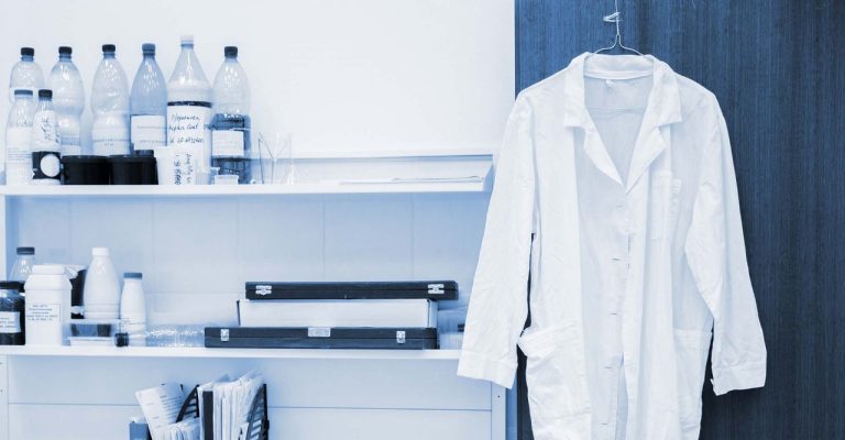 White lab coat hanging in lab