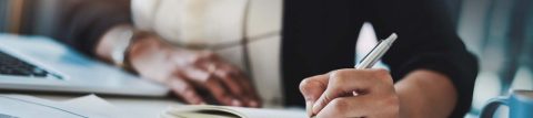 Woman writing down notes in notebook