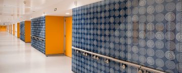 Hallway walls covered in decorative blue, white, orange glass finishes