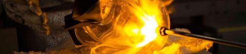 Closeup of metal, glass being forged in fire