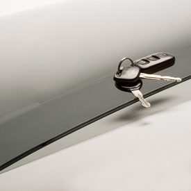 Car keys with fob on sheet of curved, tinted glass