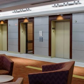 Clear glass, decorative glass accents elevators, walls in lobby setting