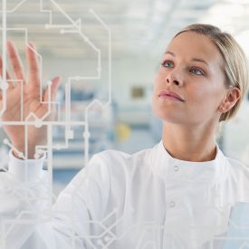 Woman in lab setting touches transparent glass display