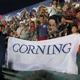 Employees sport Corning's banner at baseball game in Taiwan