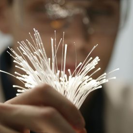 Person holds bundle of white glass fibers