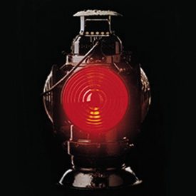 Metal railway signal lantern with bright, red light