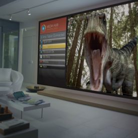 Wall-size television screen shows dinosaur movie