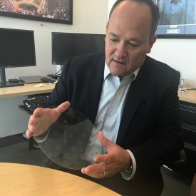 Dave Velasquez, Division Vice President of Corning® Precision Glass Solutions, shows a glass wafer