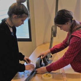 Two Girl Scouts work together to build a marble roller coaster