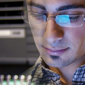 Montage: man looks down in glasses, machines in background