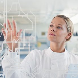 Woman in lab setting touches transparent glass display