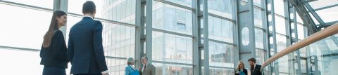 Man and woman in business attire walking through an office building.