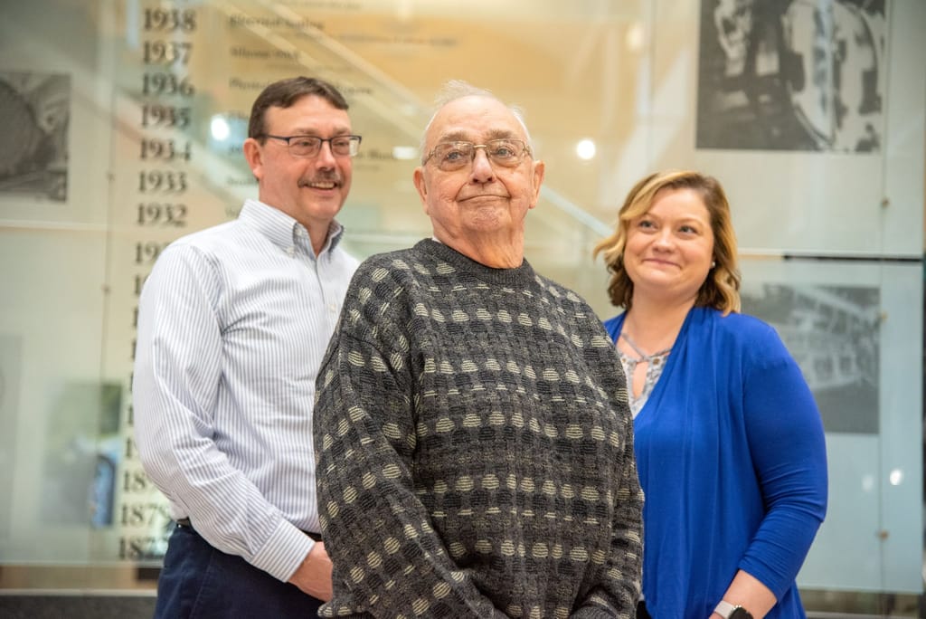Three Overstrom family members at a Corning timeline display