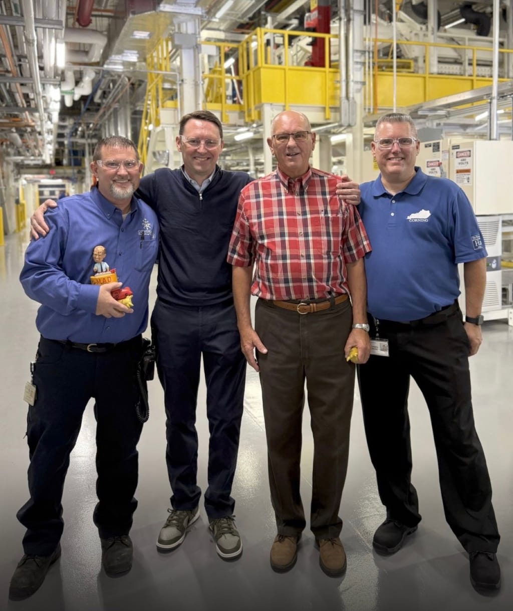 Four Corning employees standing together inside the Harrodsburg, Kentucky factory