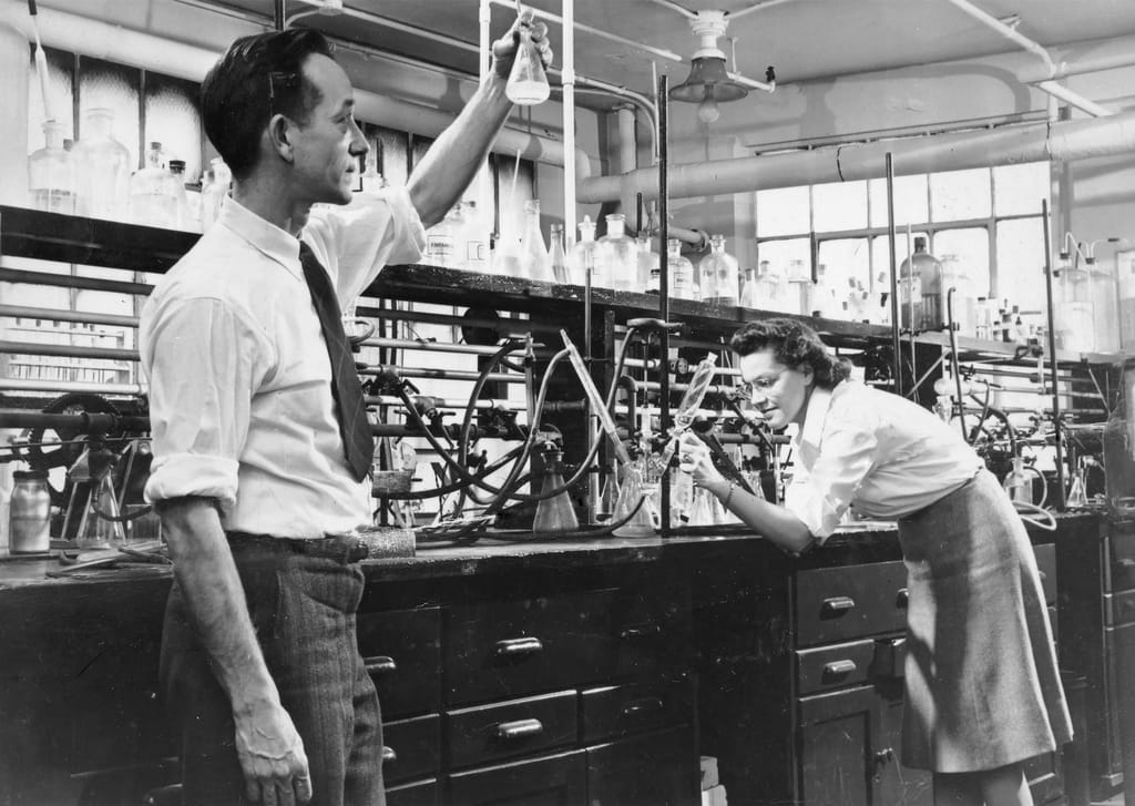 Two Corning scientists working at a 1940s laboratory bench