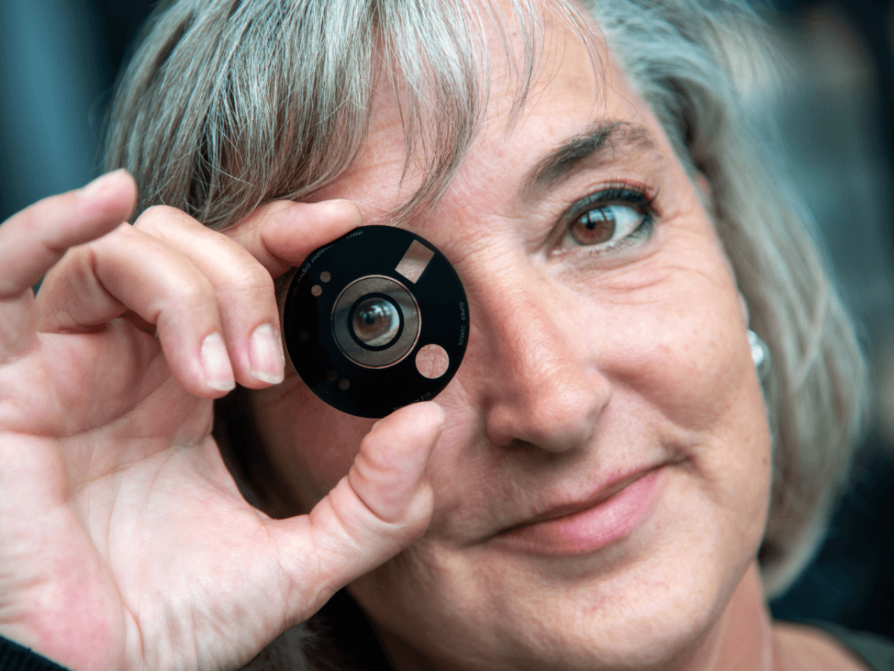 Corning program specialist Loretta Moses holds a Corning® Gorilla® Glass with DX/DX+ mobile device camera lens cover.