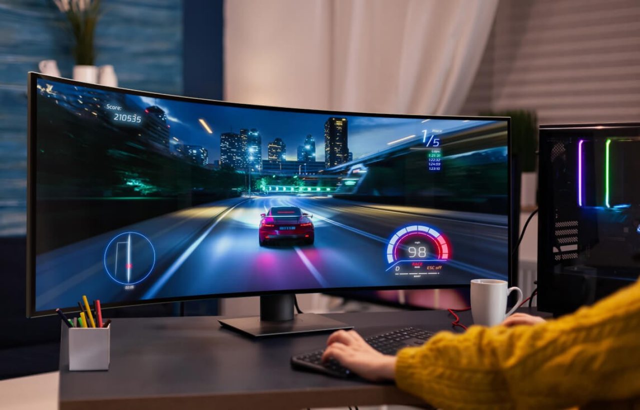 Studio shot of a premium gaming monitor displaying a car racing game