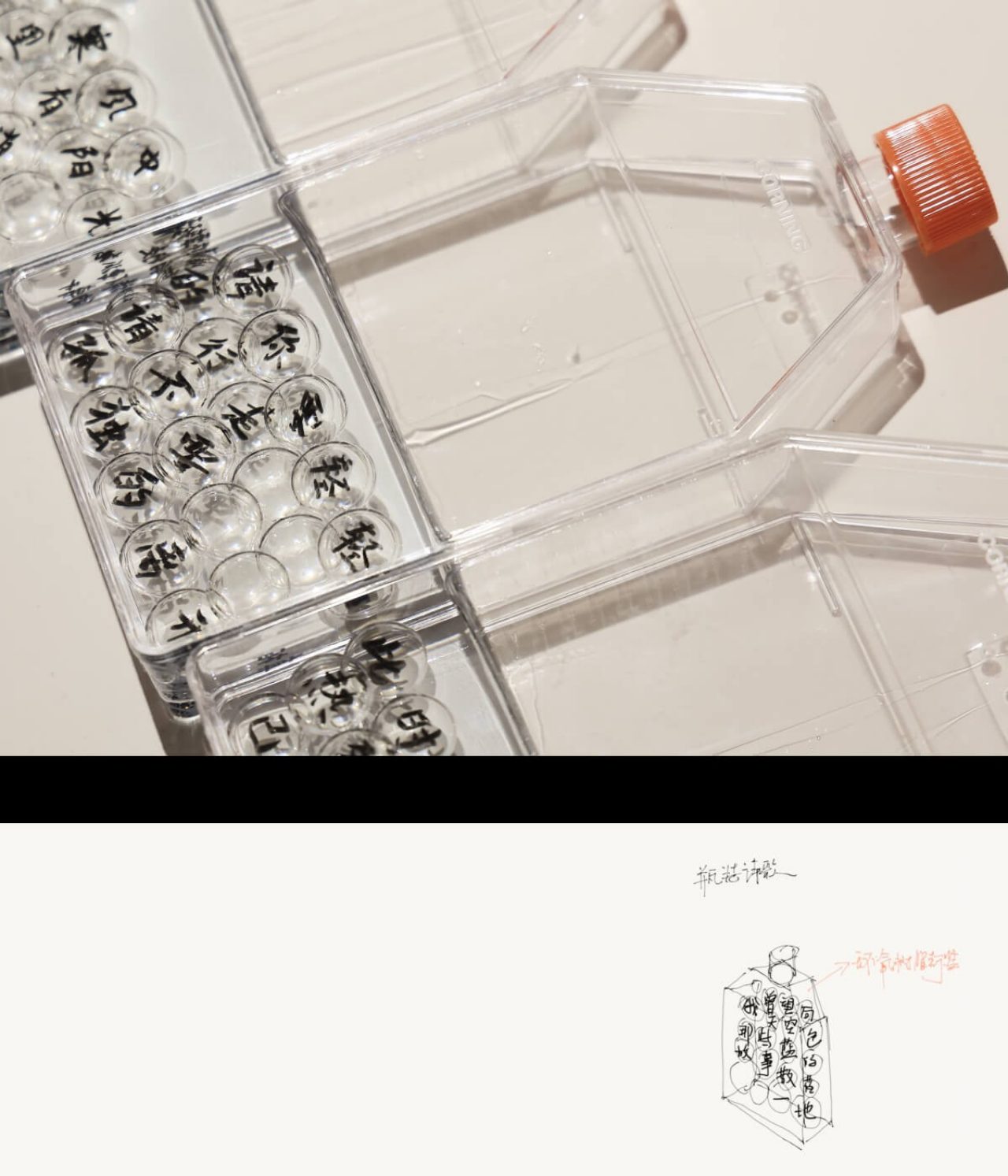 Clear glass beads etched with parts of the disassembled poem sit neatly inside a square bottle with an orange cap. The bottle is lying on it's side next to the other similar bottles.
